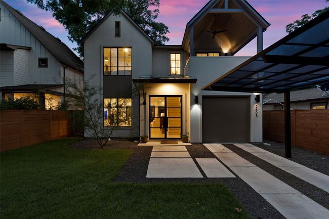 View of front of home with stucco siding, driveway, and an attached garage | Image 6
