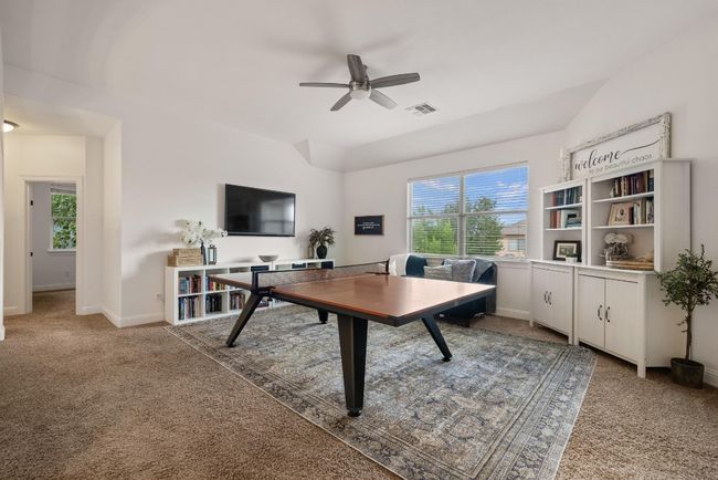 Rec room with ceiling fan, visible vents, baseboards, and carpet | Image 10