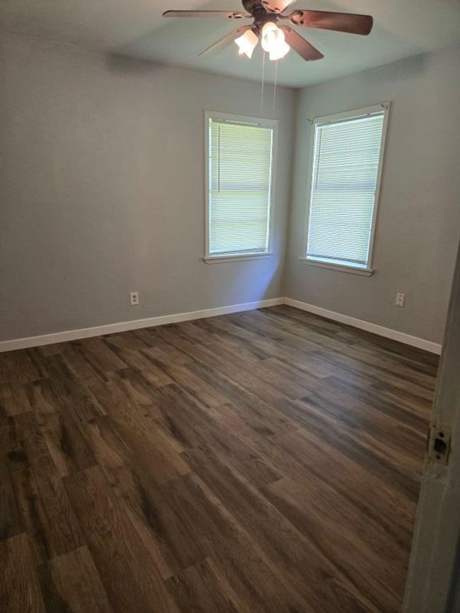 Spare room with ceiling fan and dark wood-type flooring | Image 23
