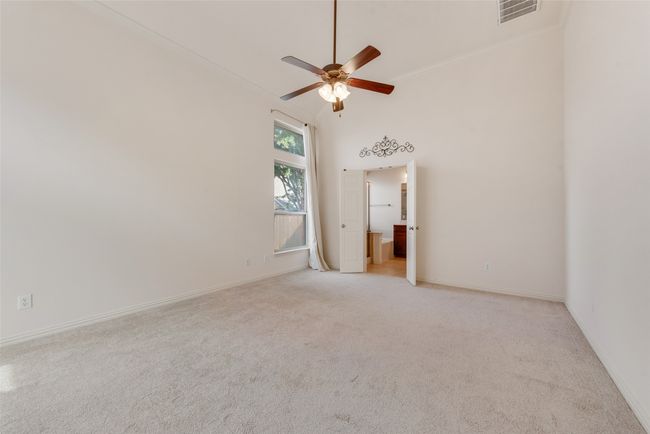 Owners bedroom featuring light carpet, ensuite bathroom, ornamental molding, and ceiling fan | Image 10
