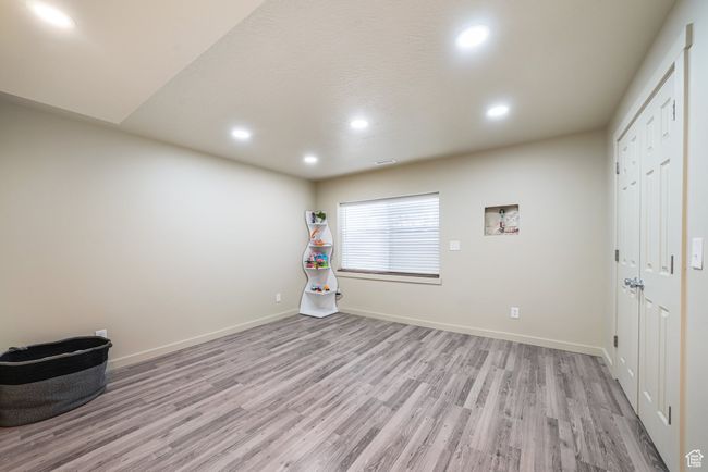 Empty room with light wood-style floors and recessed lighting | Image 25