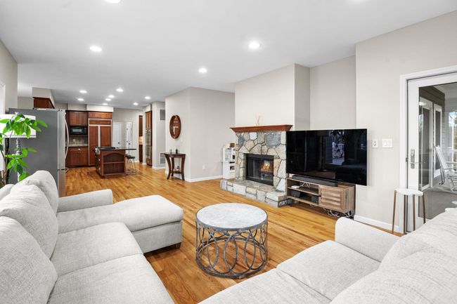 This open-concept family room blends comfort and functionality, with direct access to the deck and a cozy fireplace centerpiece. | Image 15