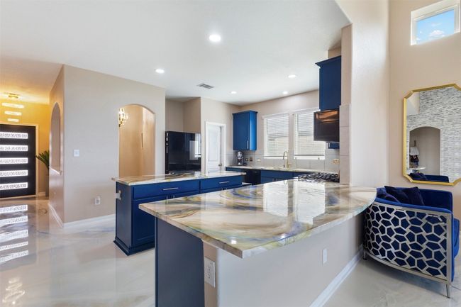 Kitchen with blue cabinets, a center island, a sink, a peninsula, and recessed lighting | Image 7