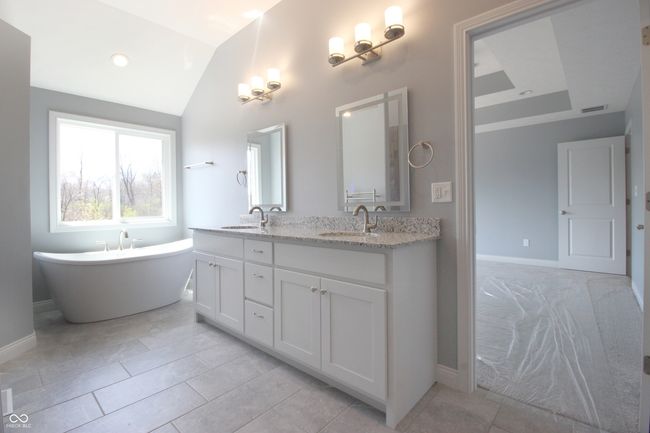 bathroom featuring a sink, visible vents, baseboards, and lofted ceiling | Image 11