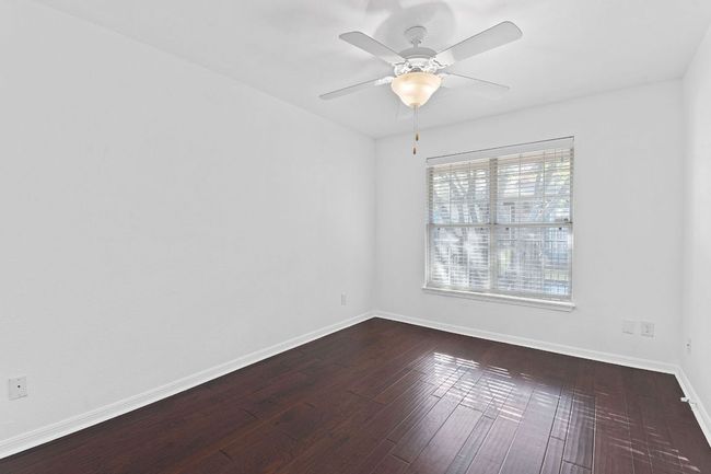 Unfurnished room with a ceiling fan, baseboards, and dark wood-style flooring | Image 25