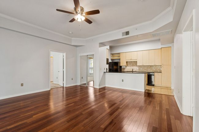Unfurnished living room featuring hardwood / wood-style flooring, a ceiling fan, and ornamental molding | Image 11