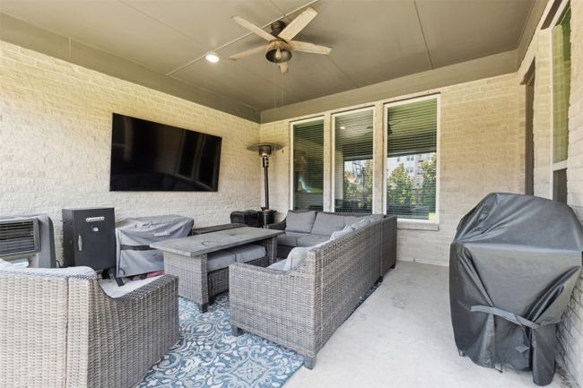 View of patio with an outdoor hangout area, a ceiling fan, and grilling area | Image 34
