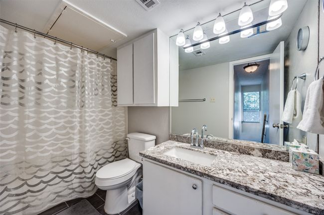 Full bathroom with toilet, granite top vanity, tile patterned flooring, and a shower tub combo | Image 15