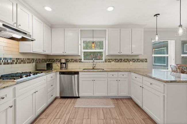 Kitchen features stainless steel appliances and a spacious island. The large windows provide ample natural light. | Image 10