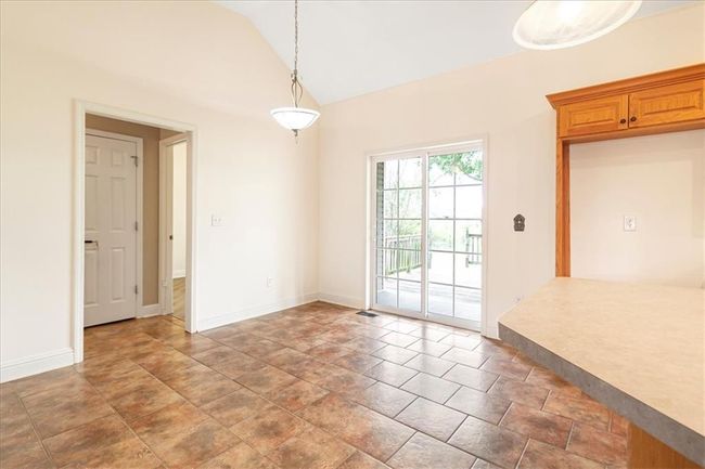 Unfurnished dining area with baseboards and vaulted ceiling | Image 12