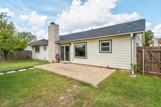 Back of property featuring a patio area, a shingled roof, and a chimney | Image 30