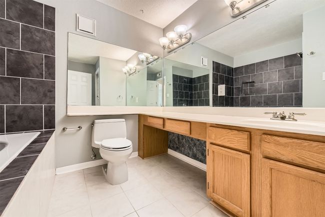 Bathroom with updated tiled tub/shower combo, vanity. | Image 11