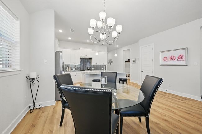Dining room featuring light wood-type flooring, a chandelier, recessed lighting, and baseboards | Image 10