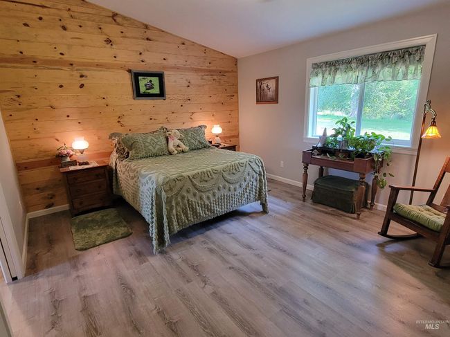Bedroom with wood finished floors, lofted ceiling, and wood walls | Image 16