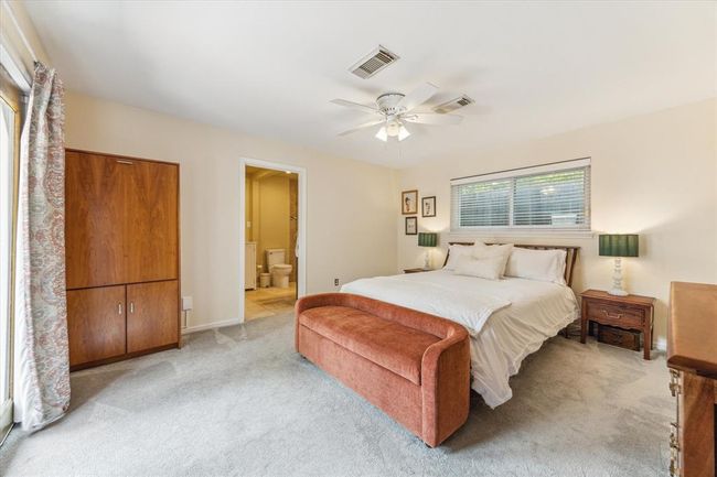 Large primary bedroom with a ceiling fan and patio access. | Image 13