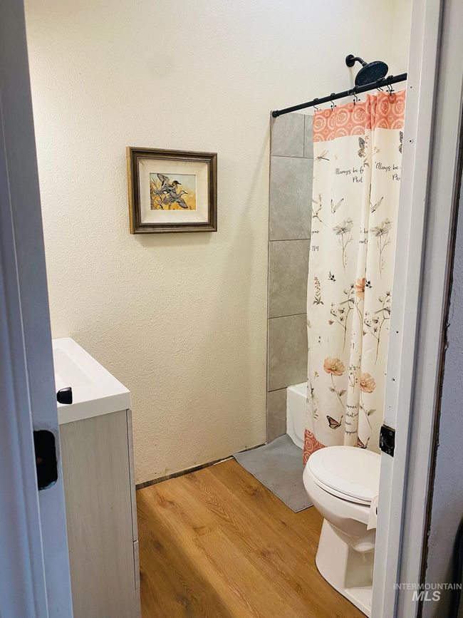 Bathroom featuring vanity, wood finished floors, and shower / tub combo with curtain | Image 18