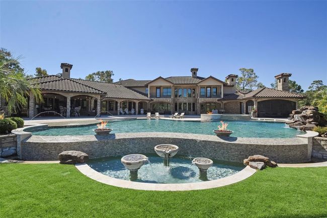 An over-size, negative edge swimming pool and attached hot tub serve as a focal point | Image 39