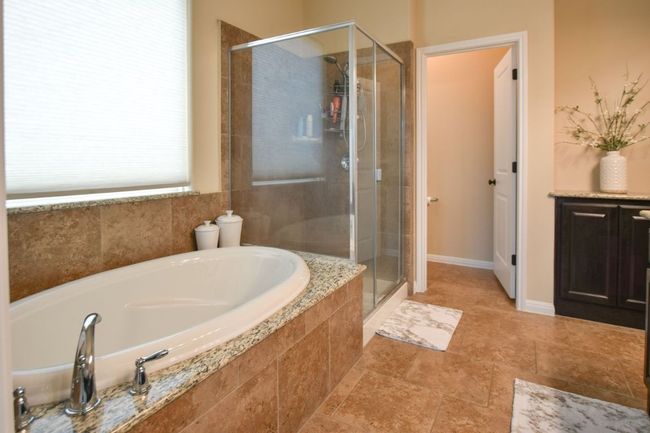 Bathroom with a stall shower and a bath | Image 16
