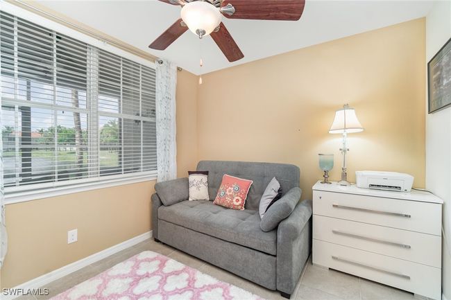 Sitting room featuring light tile patterned floors, a ceiling fan, and baseboards | Image 13