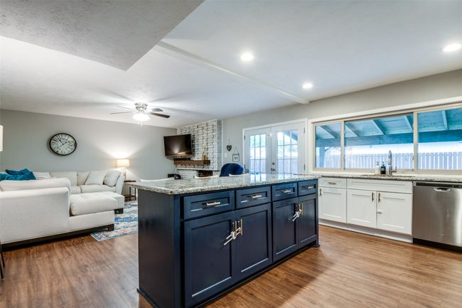 Kitchen featuring a sink, stainless steel dishwasher, white shaker style cabinetry, and wood finished floors | Image 6