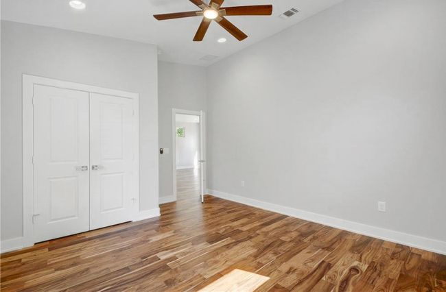 Unfurnished bedroom with recessed lighting, baseboards, wood finished floors, visible vents, and a closet | Image 25