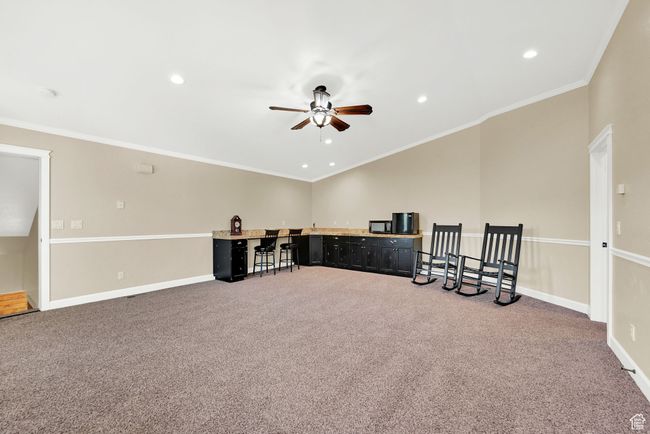 Empty room with ceiling fan, carpet floors, and crown molding | Image 44
