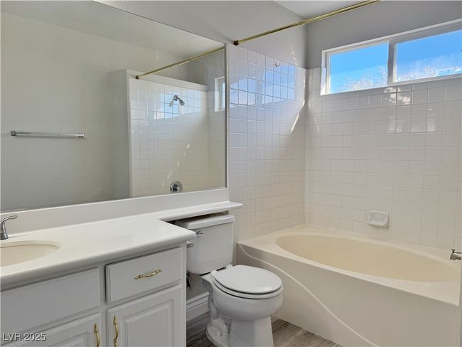 Bathroom featuring toilet, tub / shower combination, vanity, and wood finished floors | Image 32