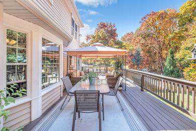 The oversized deck overlooks the inground pool and runs across the back of the house with access from the family room and dining room. | Image 3