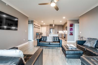 Living room featuring ceiling fan, light hardwood / wood-style floors, and crown molding | Image 1