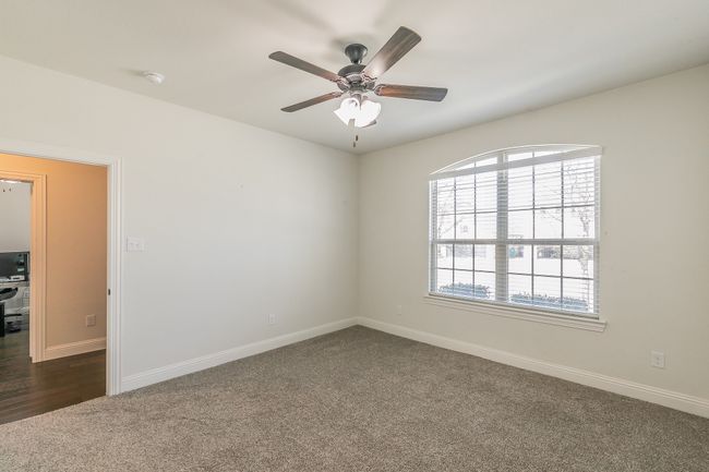 Unfurnished room with baseboards, ceiling fan, and dark colored carpet | Image 10