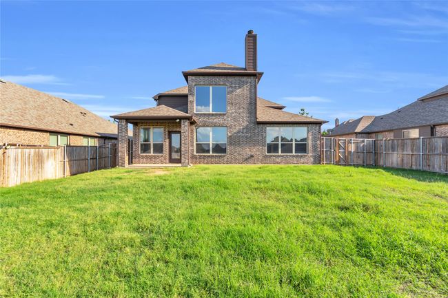 Back of property with brick siding, a chimney, and a shingled roof | Image 31