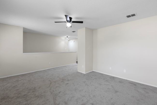 Carpeted empty room featuring ceiling fan and baseboards | Image 12