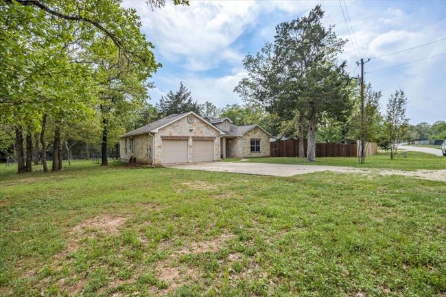 Ranch-style house with driveway, a garage, fence, and a front lawn | Image 25