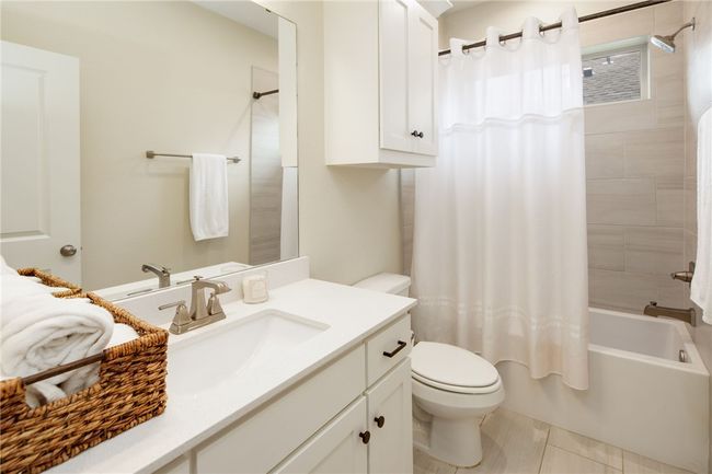 Bathroom with vanity, toilet, shower / tub combo with curtain, and tile patterned flooring | Image 15