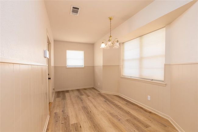 Breakfast nook has laminate wood flooring and two large windows that looks out into the back yard. | Image 21