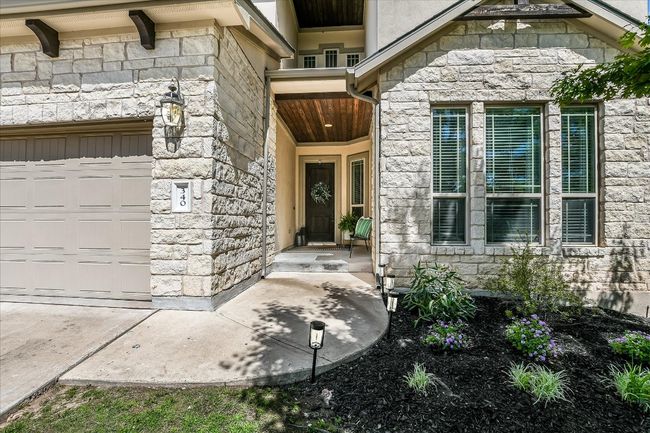 View of exterior entry with an attached garage and stone siding | Image 4