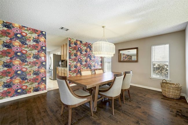 Dining room featuring plenty of natural light, wood finished floors, a textured ceiling, and a chandelier | Image 5