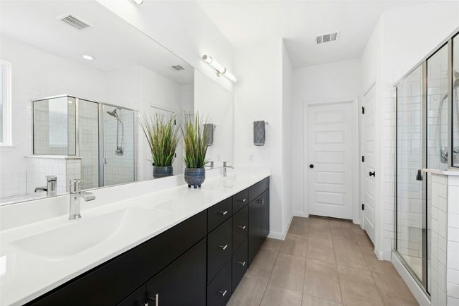 Primary bathroom with nice dark cabinets and white scheme, dual vanity and separate tub and shower | Image 12