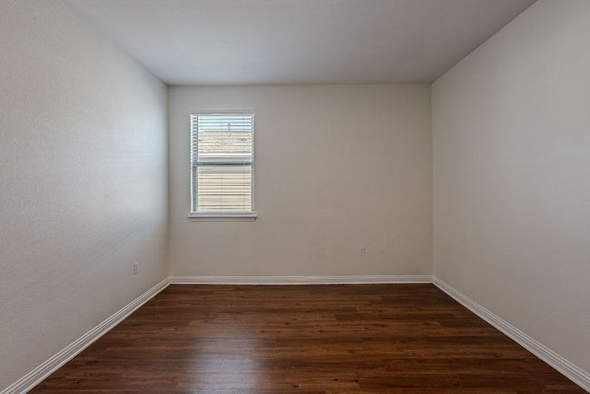 Spare room featuring baseboards and dark wood-style flooring | Image 25