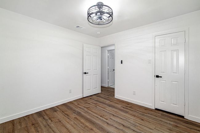 Unfurnished bedroom with wood finished floors and baseboards | Image 27