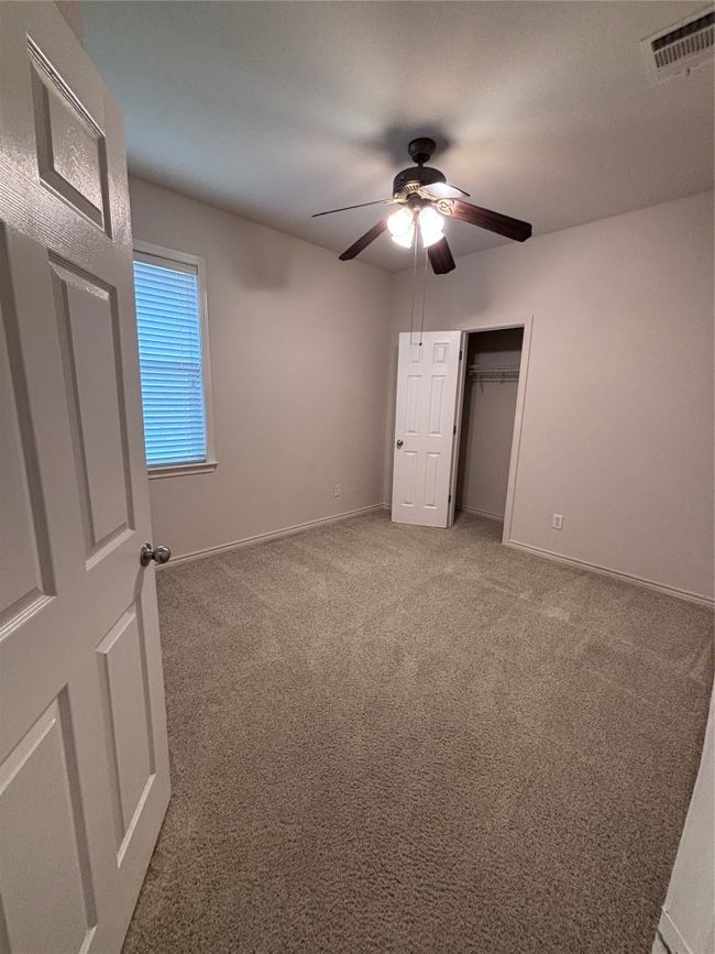 Unfurnished bedroom featuring carpet floors, a ceiling fan, and a closet | Image 11