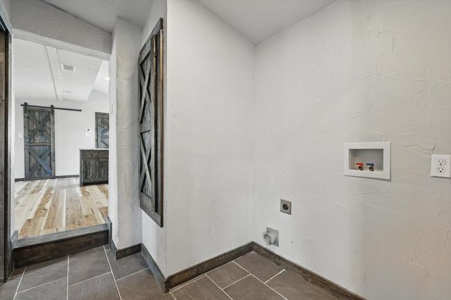Washroom with visible vents, laundry area, electric dryer hookup, washer hookup, and a barn door | Image 27