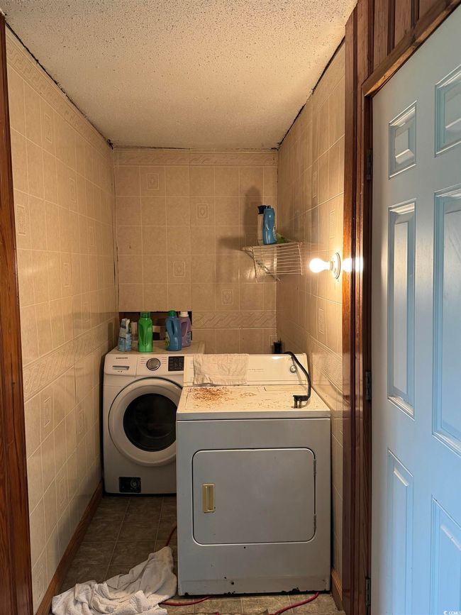 Laundry area featuring tile walls, washer / dryer, a textured ceiling, and tile patterned floors | Image 15