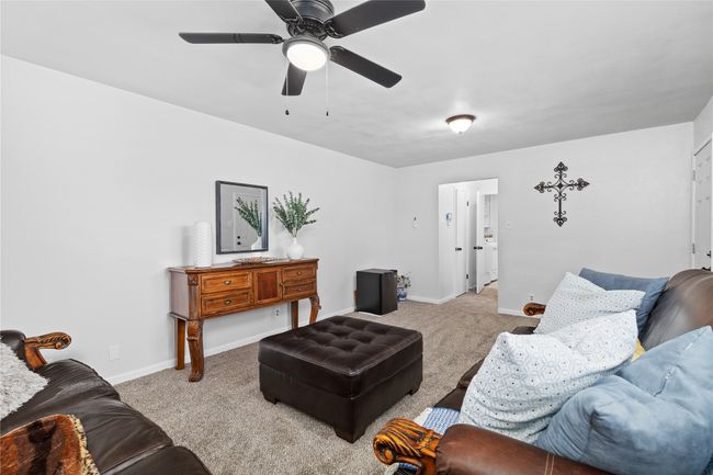 Living room featuring ceiling fan, carpet, and baseboards | Image 18