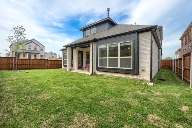 Rear view of property with brick siding, a patio area, a lawn, and a fenced backyard | Image 32