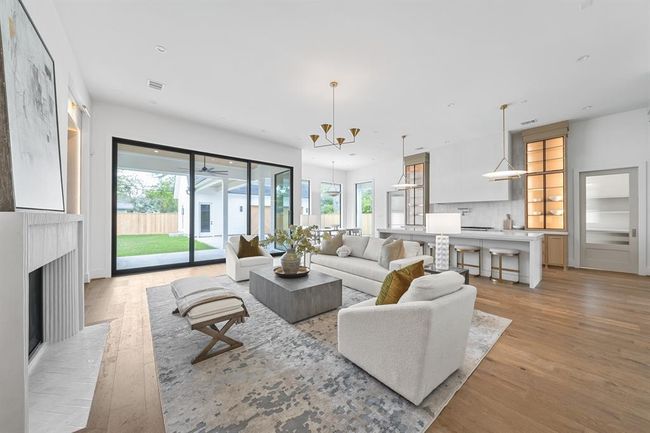 Designed for both gathering and retreat, the living area features custom white oak built-ins with integrated lighting, adding warmth and dimension to the modern layout. Wide-plank flooring and thoughtfully placed windows enhance the open, airy ambiance. | Image 22