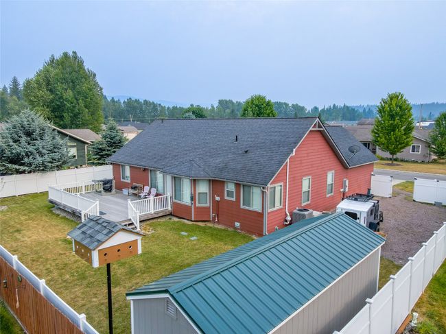 Back of house featuring cooling unit, a wooden deck, a fenced backyard, and a lawn | Image 19