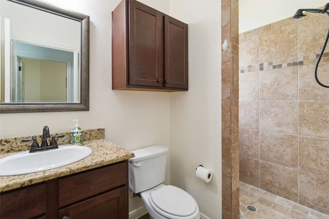 Full bathroom featuring vanity, a tile shower, and toilet | Image 15