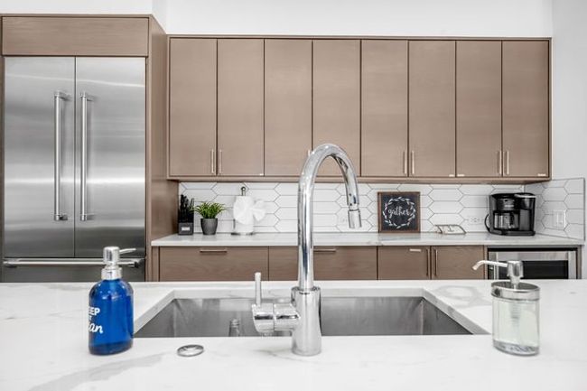 Kitchen featuring tasteful backsplash, light stone counters, and built in fridge | Image 25