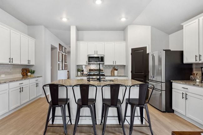The kitchen features an extended wall of cabinets perfect for a bar or coffee station. | Image 7